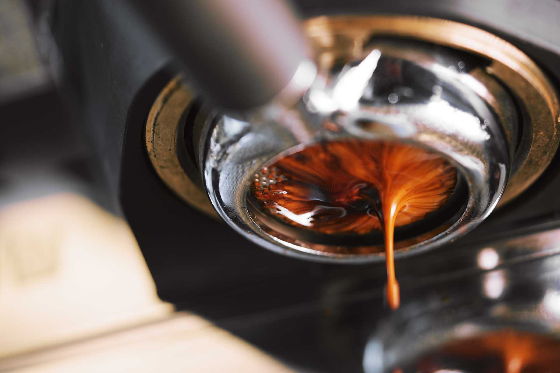 Estrazione di espresso con crema da macchina professionale, dettaglio del flusso di caffè
