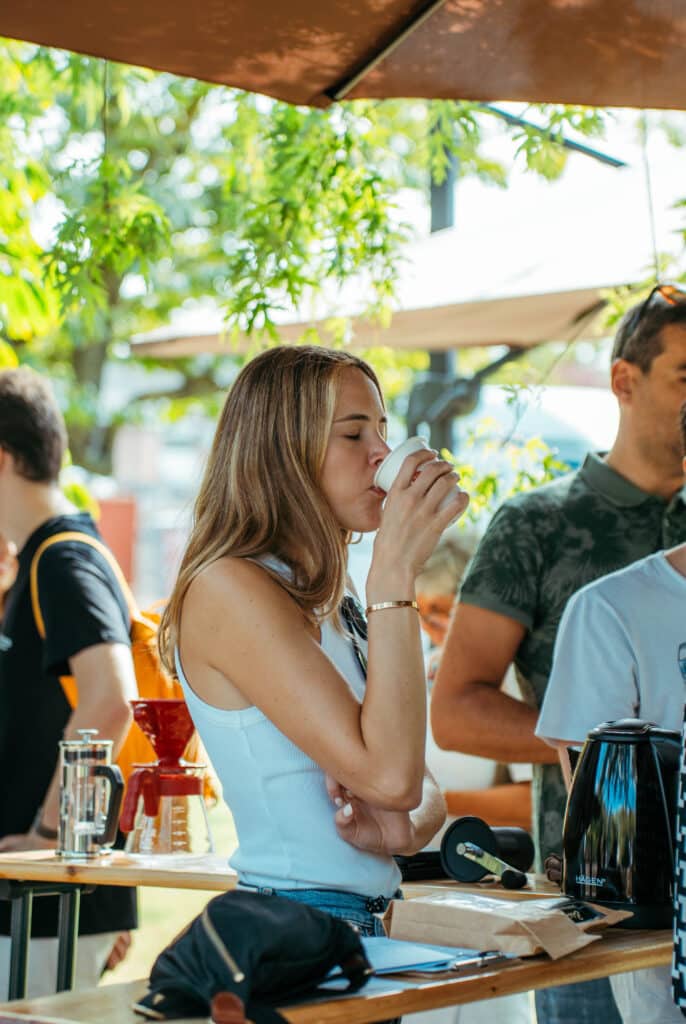 Ragazza che beve il caffè LaBrasiliana in giardino